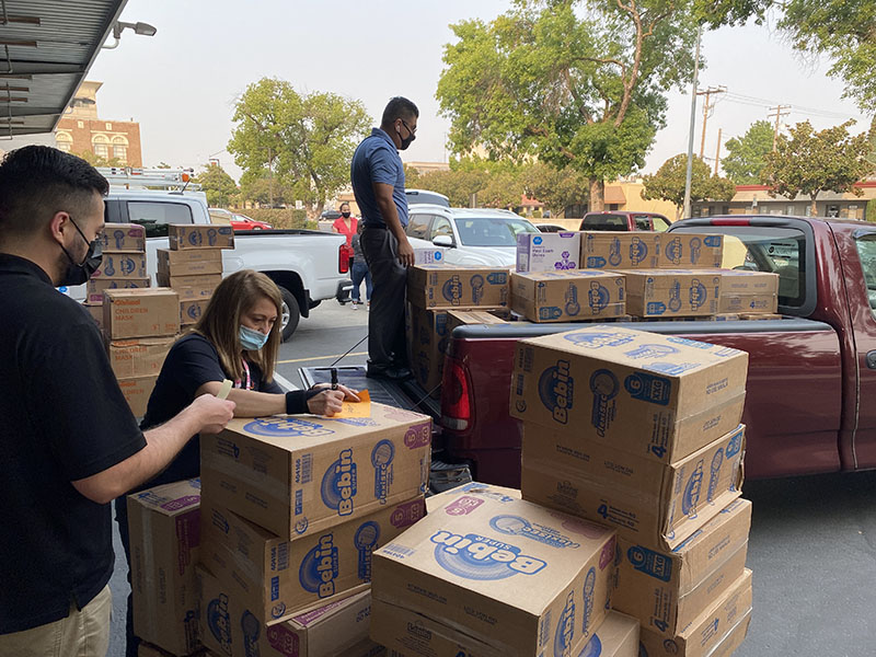 Staff unloading boxes from a pickup truck